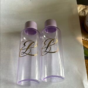 Estée Lauder Set of Two Purple and Gold Bottles. Plastic 3 ounce travel bottles.